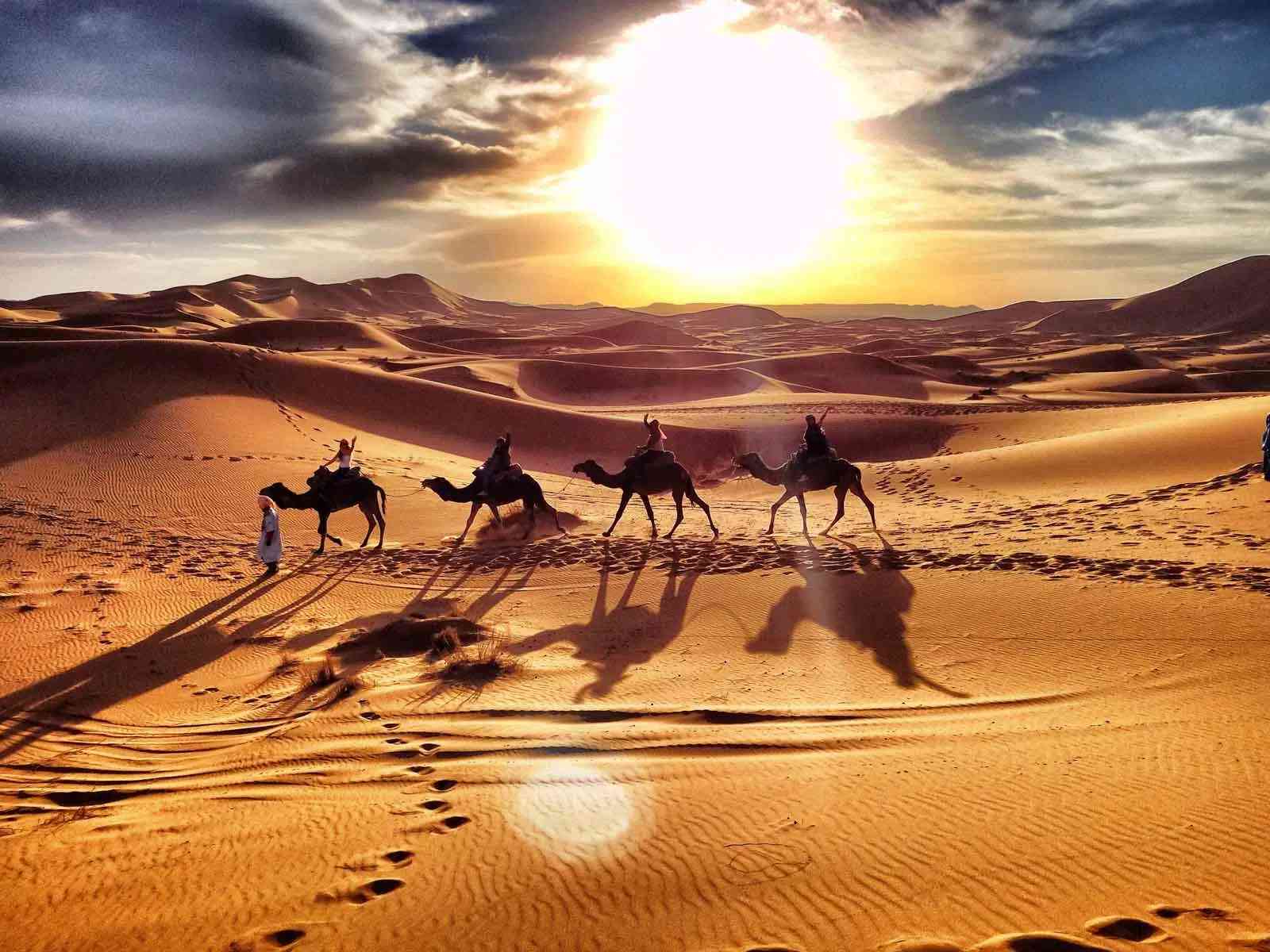 Experience the magic of a Sahara Desert sunset on a camel trek, a highlight of the 4-day tour from Marrakech.
